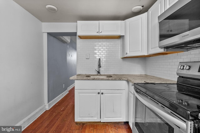 kitchen with white cabinetry, sink, light stone counters, and appliances with stainless steel finishes