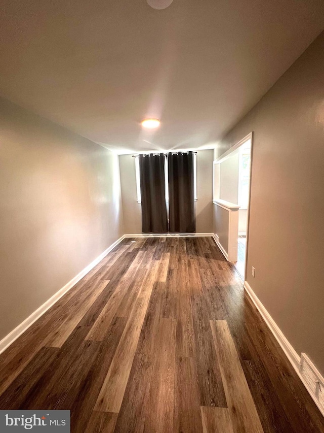 unfurnished room featuring dark wood-type flooring