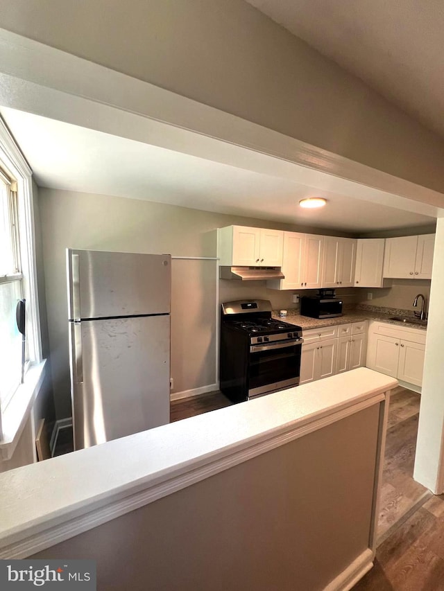 kitchen featuring dark hardwood / wood-style floors, a healthy amount of sunlight, white cabinetry, and appliances with stainless steel finishes