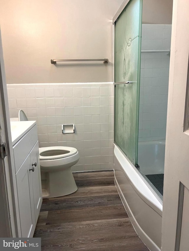 full bathroom with wood-type flooring, vanity, toilet, and tile walls