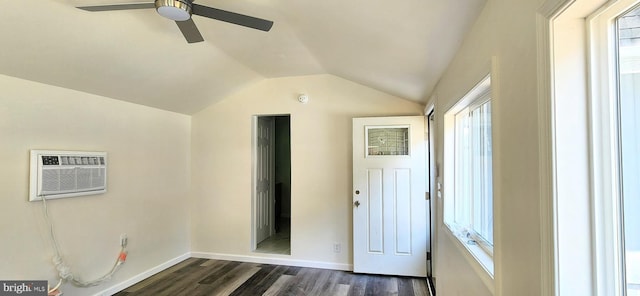 interior space with dark hardwood / wood-style flooring, vaulted ceiling, a wall unit AC, and ceiling fan