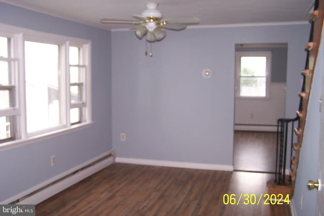 unfurnished room featuring ceiling fan, crown molding, baseboard heating, and dark wood-type flooring