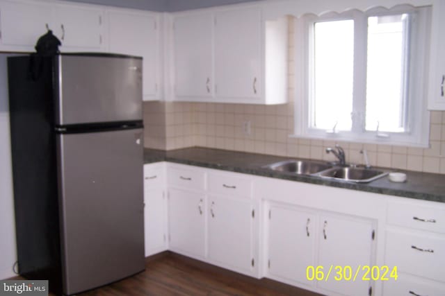 kitchen featuring white cabinetry, sink, dark hardwood / wood-style flooring, stainless steel fridge, and decorative backsplash