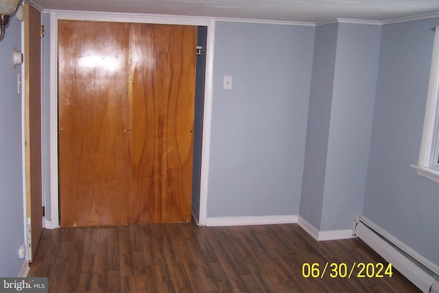 spare room with a healthy amount of sunlight, dark hardwood / wood-style flooring, a baseboard radiator, and ornamental molding