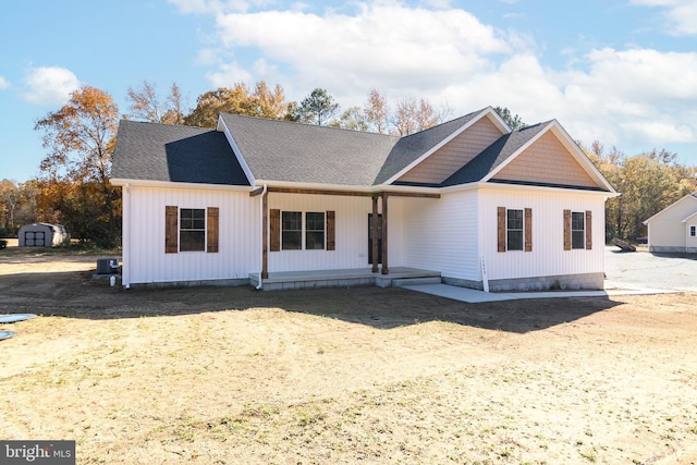 view of front of home featuring a porch and a shed