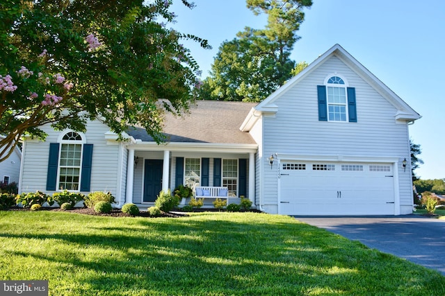 view of front of house with a front lawn, covered porch, and a garage