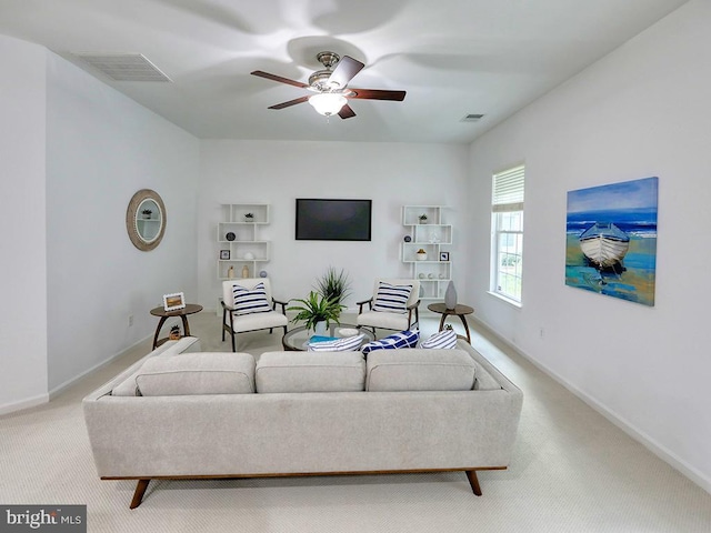 carpeted living room with ceiling fan