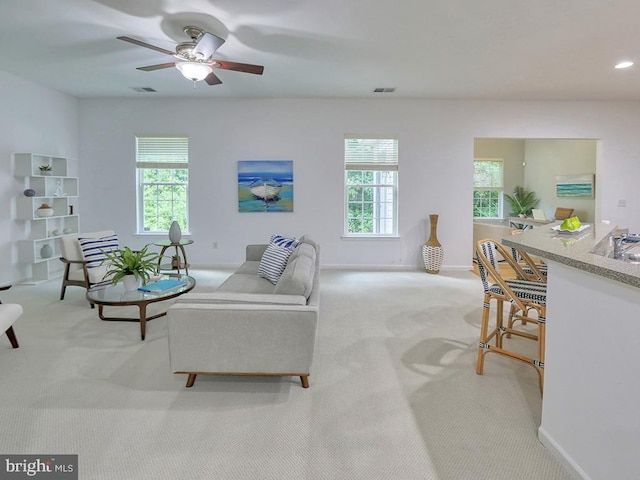 carpeted living room with ceiling fan