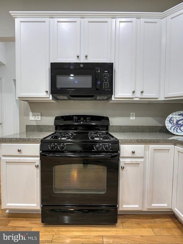 kitchen with black appliances and white cabinetry