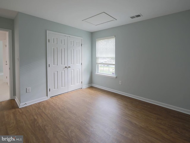 unfurnished bedroom with dark hardwood / wood-style floors and a closet