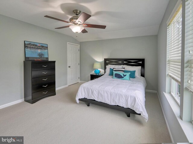 carpeted bedroom featuring multiple windows, ceiling fan, and lofted ceiling