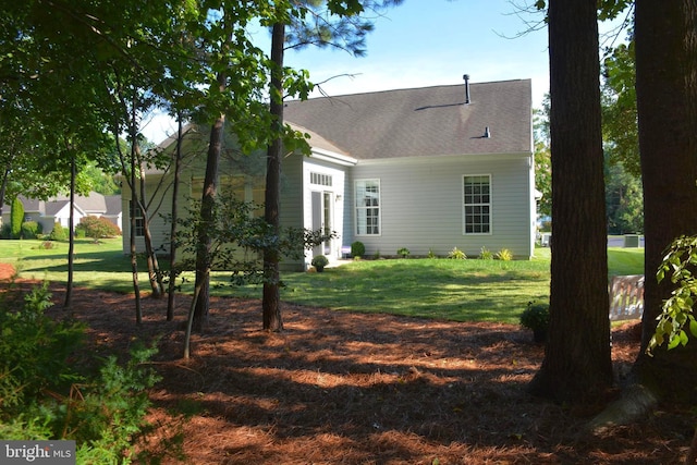 rear view of property featuring a lawn