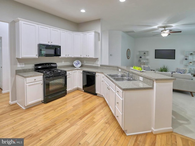 kitchen featuring white cabinetry, sink, kitchen peninsula, black appliances, and light wood-type flooring