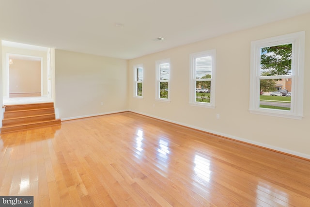 unfurnished living room with light wood-style flooring and baseboards