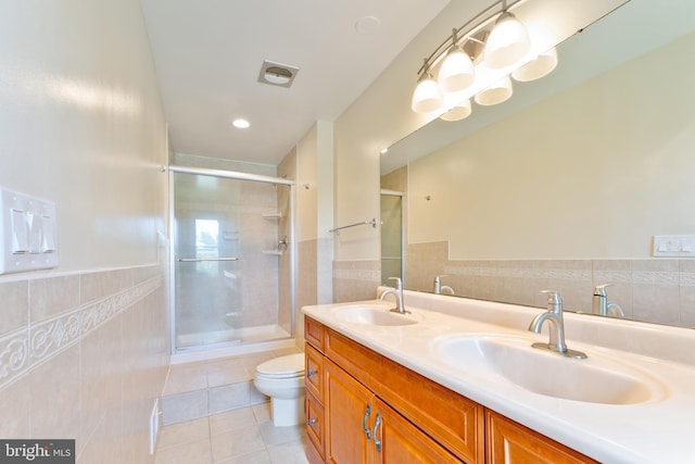 full bathroom with tile patterned flooring, a sink, tile walls, and a shower stall