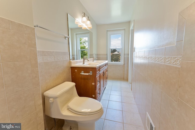 bathroom with visible vents, wainscoting, tile patterned floors, vanity, and tile walls