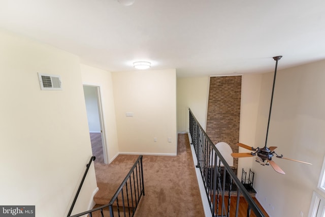 hall with visible vents, carpet flooring, an upstairs landing, and baseboards