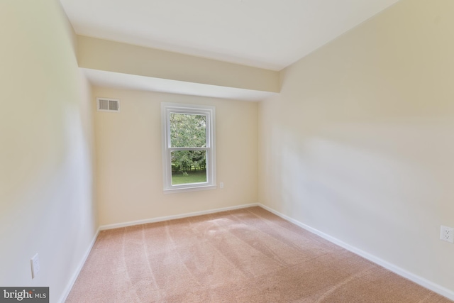 carpeted empty room featuring visible vents and baseboards