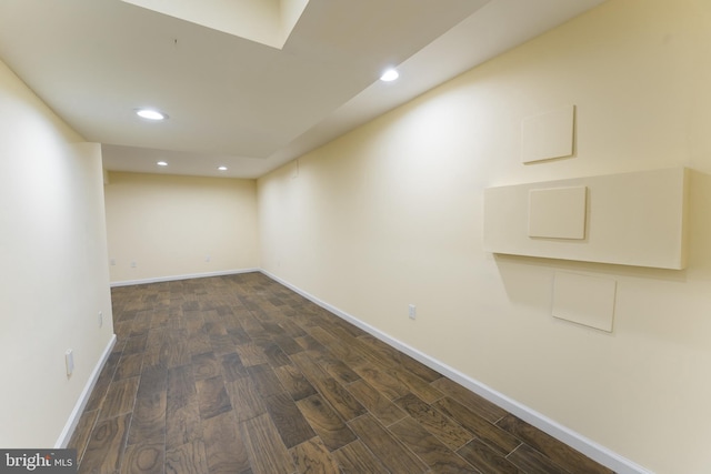 below grade area with baseboards, dark wood-style flooring, and recessed lighting