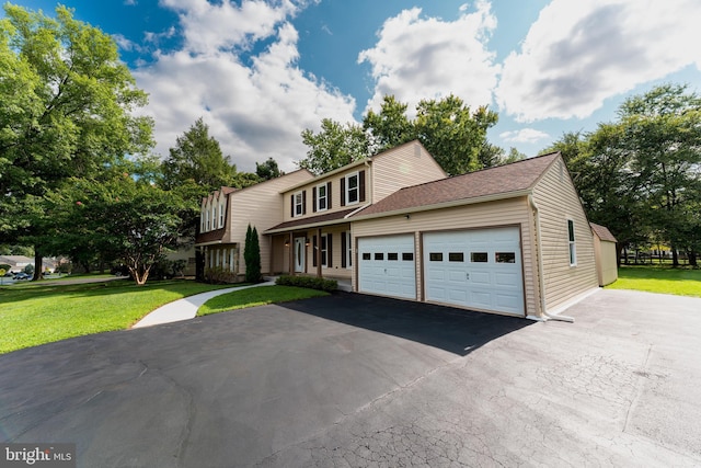 view of front of home with a garage, driveway, and a front yard