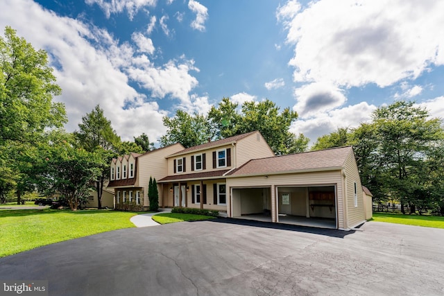 view of front of house featuring driveway, a shingled roof, an attached garage, and a front yard