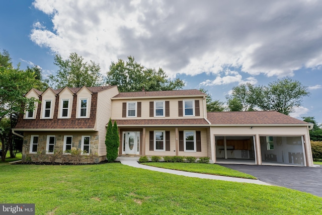 view of property featuring a garage, a shingled roof, stone siding, aphalt driveway, and a front yard