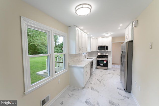 kitchen featuring marble finish floor, baseboards, visible vents, and stainless steel appliances