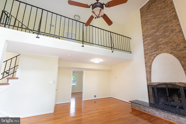 unfurnished living room featuring stairs, baseboards, and wood finished floors