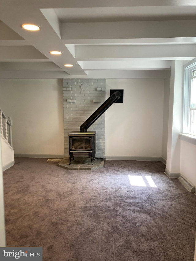 unfurnished living room featuring carpet flooring and a wood stove