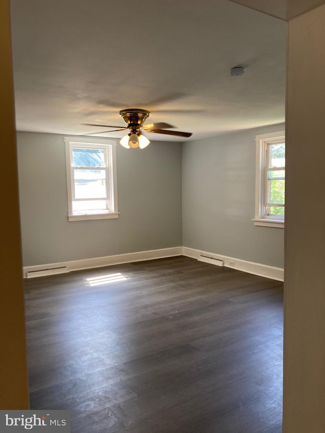 spare room with baseboard heating, ceiling fan, and dark hardwood / wood-style flooring