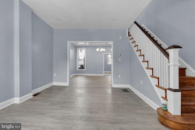 foyer with light wood-type flooring and an inviting chandelier