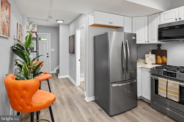 kitchen featuring white cabinetry, stainless steel appliances, and light hardwood / wood-style flooring