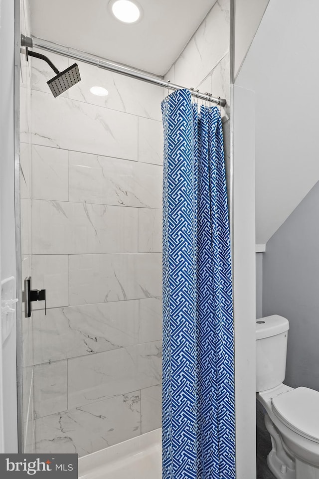 bathroom with a shower with curtain and toilet