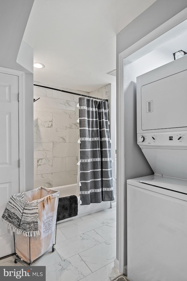 clothes washing area featuring stacked washer and dryer