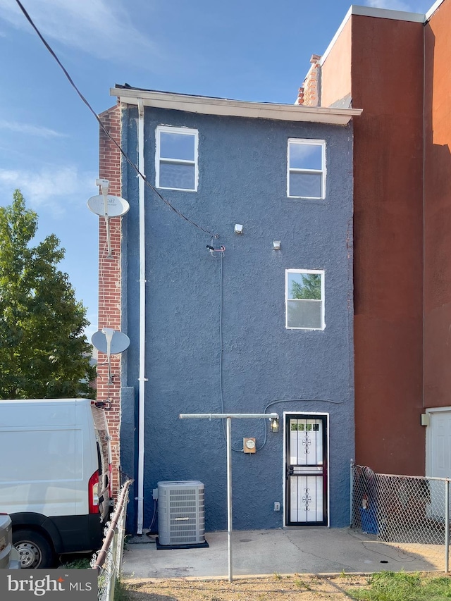 rear view of house featuring central air condition unit