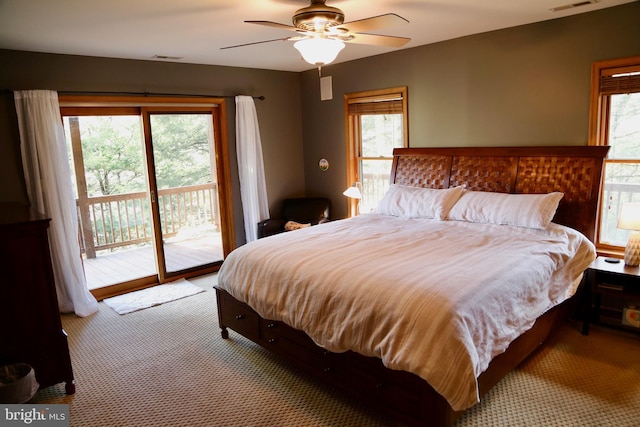 carpeted bedroom featuring ceiling fan, access to exterior, and multiple windows