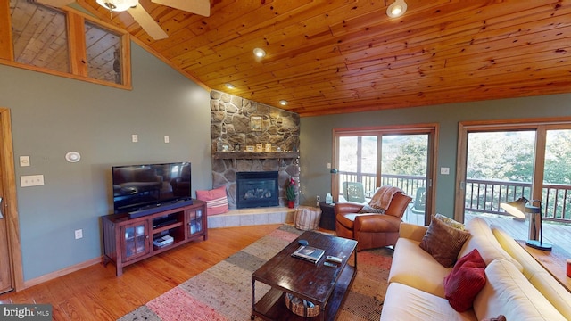 living room with ceiling fan, light hardwood / wood-style floors, lofted ceiling, a fireplace, and wood ceiling