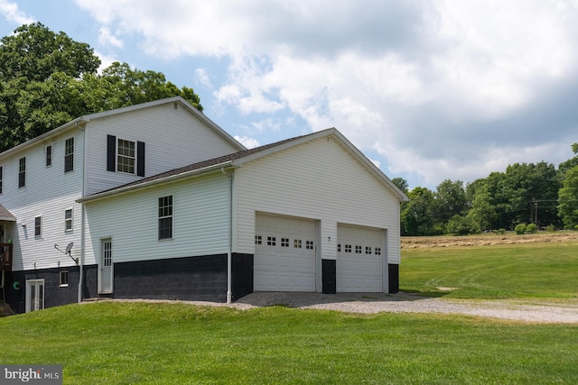 view of side of home with a yard and a garage