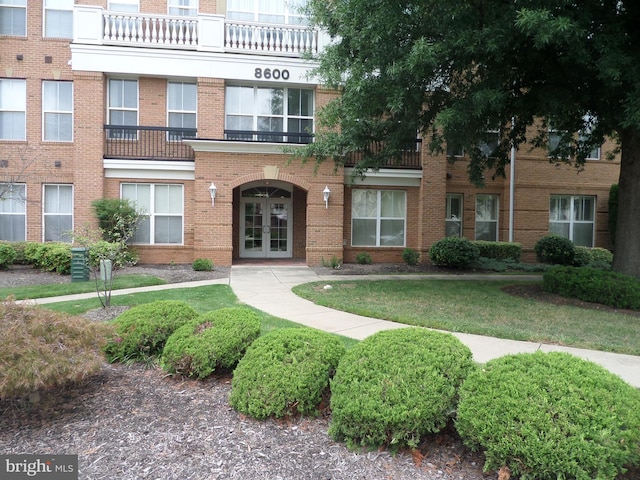 view of front facade with a front lawn and french doors