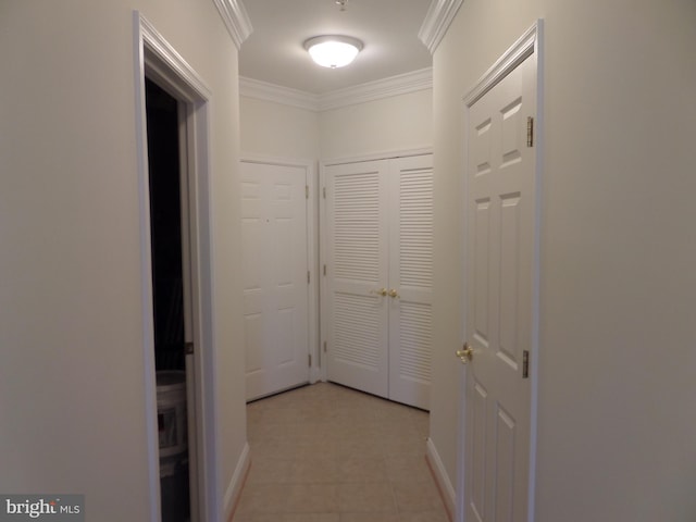 hallway with crown molding and light tile patterned floors