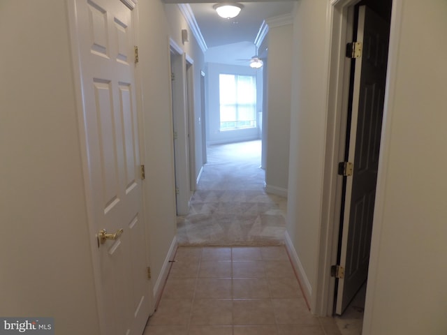 hall featuring crown molding and light tile patterned floors