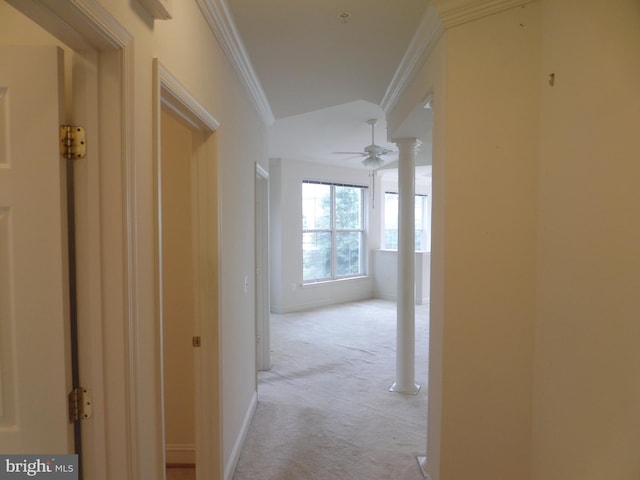 hall featuring decorative columns, light colored carpet, and crown molding