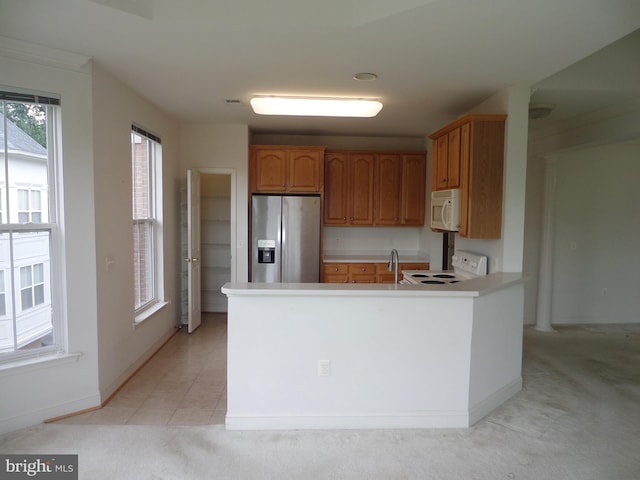 kitchen with white appliances, sink, light carpet, and kitchen peninsula