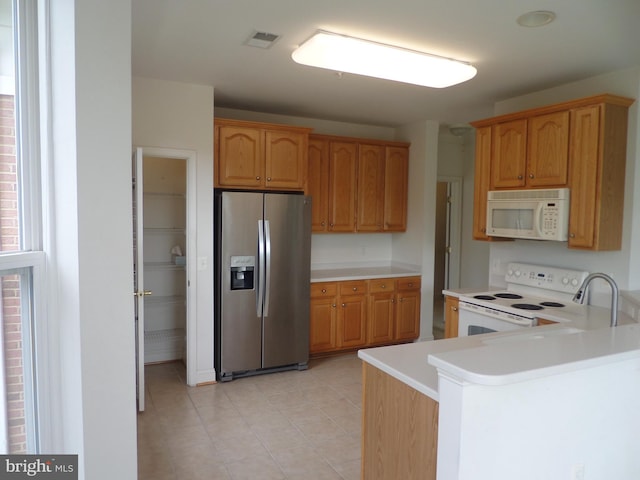 kitchen with sink, kitchen peninsula, and white appliances