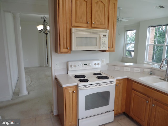 kitchen featuring ceiling fan with notable chandelier, white appliances, pendant lighting, light tile patterned floors, and sink