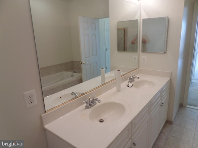 bathroom with tile patterned flooring, a washtub, and vanity