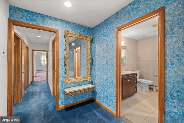 hallway with light tile patterned floors and baseboard heating