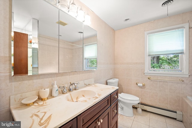 bathroom featuring a healthy amount of sunlight, tile walls, and a baseboard radiator