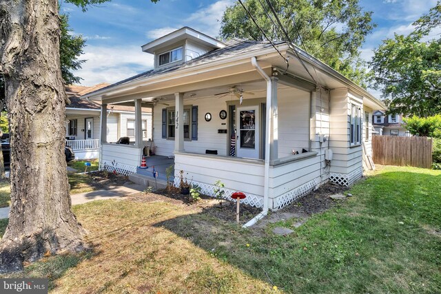 bungalow-style home with ceiling fan, a porch, and a front yard