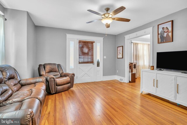 living room with ceiling fan and light hardwood / wood-style flooring